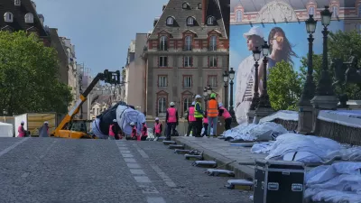 Workers continue preparations on the wrapped Pont Neuf bridge project, titled Pont Neuf Cavern, by French artist JR, in Paris, Saturday, May 16, 2026, ahead of its inauguration on June 6. (AP Photo/Michel Euler)
