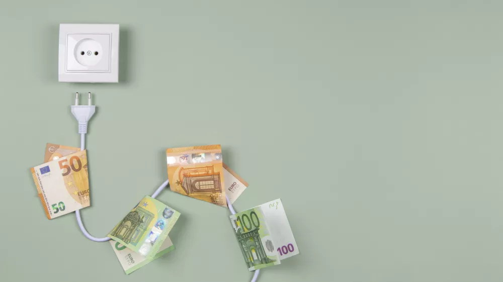 Electric power plug with euro banknotes on it and electric socket on light green background. Electricity cost and expensive energy concept.