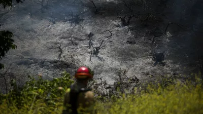 A firefighter walks towards a charred hillside during a wildfire known as the Sandy Fire, in Simi Valley, California, U.S., May 18, 2026. REUTERS/Daniel Cole   TPX IMAGES OF THE DAY / Foto: Daniel Cole