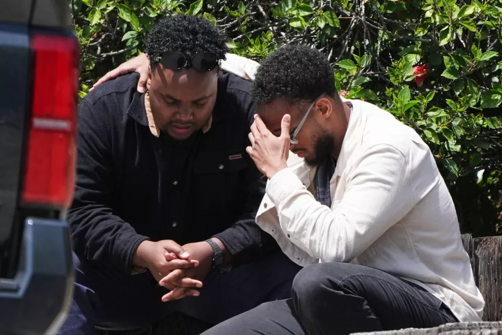 Two men embrace at the scene of a shooting outside the Islamic Center of San Diego Monday, May 18, 2026, in San Diego. (AP Photo/Gregory Bull)
