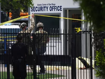 A body is covered with a tarp at the scene of a shooting outside the Islamic Center of San Diego Monday, May 18, 2026, in San Diego. (AP Photo/Gregory Bull)