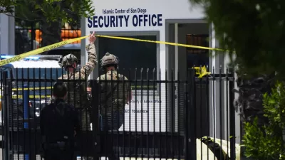 A body is covered with a tarp at the scene of a shooting outside the Islamic Center of San Diego Monday, May 18, 2026, in San Diego. (AP Photo/Gregory Bull)