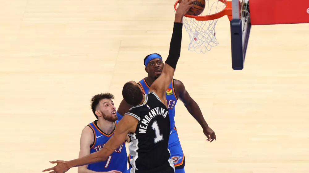 San Antonio Spurs forward Victor Wembanyama (1) shoots against Oklahoma City Thunder center Chet Holmgren (7) and guard Luguentz Dort during the second overtime of Game 1 in a third-round NBA basketball playoffs series Monday, May 18, 2026, in Oklahoma City. (AP Photo/Nate Billings)