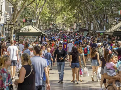 Barcelona, Spain - July 5, 2016: Hundreds of people promenading in the busiest street of Barcelona, the Ramblas. The street extends 1.2 kilometers connects the Placa de Catalunya in the centre with the Christopher Columbus Monument at Port Vell.