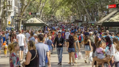 Barcelona, Spain - July 5, 2016: Hundreds of people promenading in the busiest street of Barcelona, the Ramblas. The street extends 1.2 kilometers connects the Placa de Catalunya in the centre with the Christopher Columbus Monument at Port Vell.