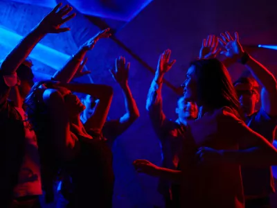 Joyful dancers with raised hands enjoying prom