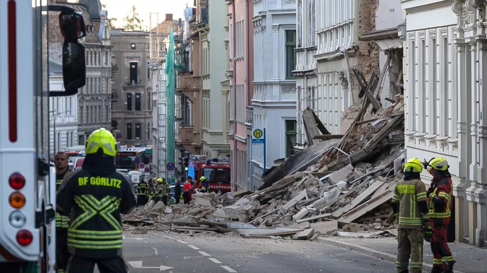 Police and firefighters stand near a collapsed house in the city center of Goerlitz, Germany, Monday, May 18, 2026. (Paul Glaser/dpa via AP)