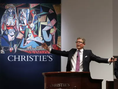 Auctioneer Jussi Pylkkanen takes bids on Pablo Picasso's Women of Algiers (Version O), which sold for nearly 9.4 million, making it set a world record for artwork at auction during a sale at Christie's Rockefeller Center in New York, Monday, May 11, 2015. Experts say high art prices are driven by artworks' investment value and by wealthy new and established collectors seeking out the very best works. (AP Photo/Kathy Willens)
