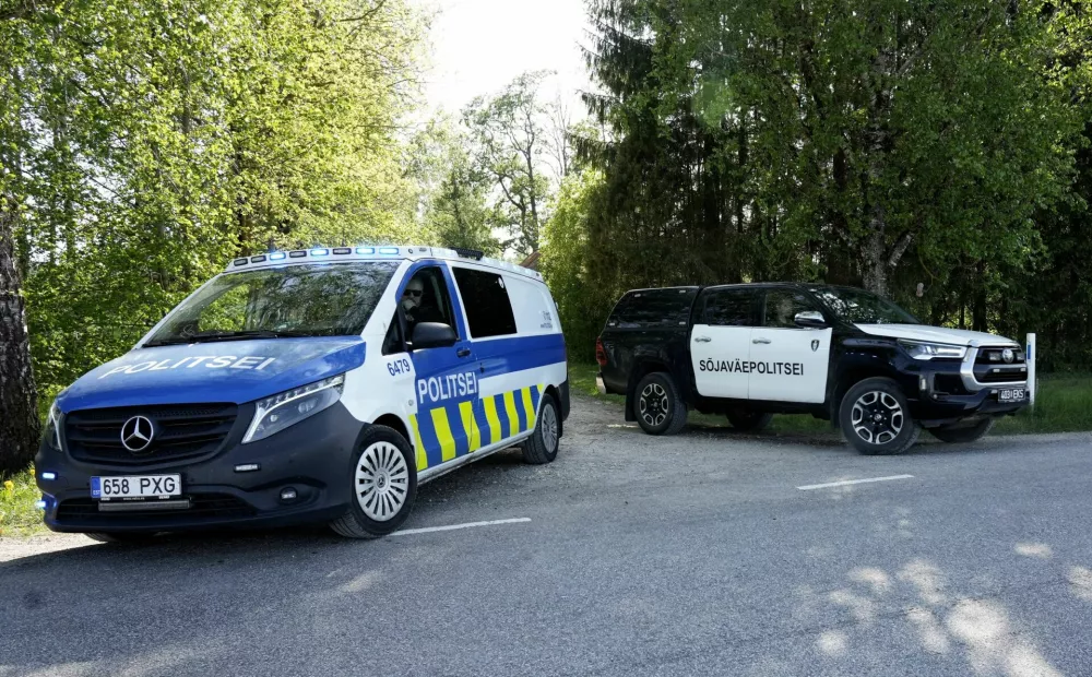 Police guard the perimeter of a drone crash site as a military police car leaves, near Kablakula village, Estonia May 19, 2026. REUTERS/Ints Kalnins