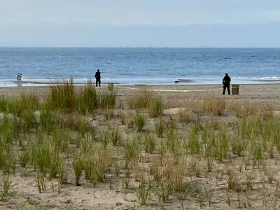 FILE - New York Police investigators examine a stretch of beach at Coney Island where three children were found dead in the surf, Sept. 12, 2022, in New York. (AP Photo/Joseph Frederick, File)