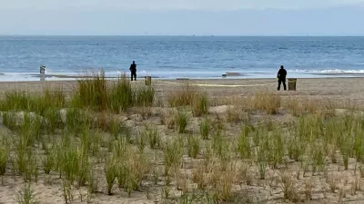 FILE - New York Police investigators examine a stretch of beach at Coney Island where three children were found dead in the surf, Sept. 12, 2022, in New York. (AP Photo/Joseph Frederick, File)