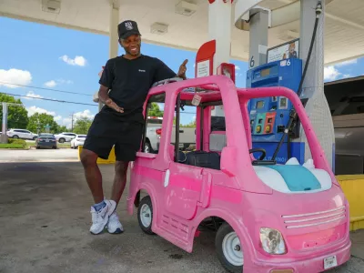 Mali Hightower, 29, poses with what he describes as a self-created gas saver, a pink Power Wheels Barbie Dream Camper, at a gas station in Ellenwood, Georgia, U.S., May 18, 2026. REUTERS/Jayla Whitfield-Anderson