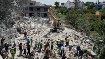 Rescue workers search for victims in the rubble of a destroyed house that was hit on Tuesday by an Israeli airstrike, in the village of Deir Qanoun al Nahr, south Lebanon, Wednesday, May 20, 2026. (AP Photo/Mohammed Zaatari)