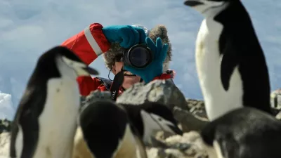 Oct 30, 2008 - Antarctica - Half Moon Island is a crescent-shaped islet that lies in the entrance to Moon Bay between Livingston and Greenwich Islands. It is home of the Argentine Teniente Camara Station. This beautiful location has Chinstrap penguin nests over majestic basaltic columns. Pictured: Tourist taking a photograph in a Chinstrap Penguin (Pygoscelis antarcticus) rookery.Model Released photo. (Credit Image: ? Kike Calvo/VW Pics/ZUMA Press)