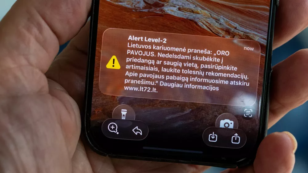 The phone shows the received message "The Lithuanian military reports: "AIR DANGER. Hurry to cover or a safe place without delay, take care of your loved ones, wait for further recommendations. We will inform you about the end of the danger in a separate message", in Vilnius, Lithuania, Wednesday, May 20, 2026. (AP Photo/Mindaugas Kulbis)