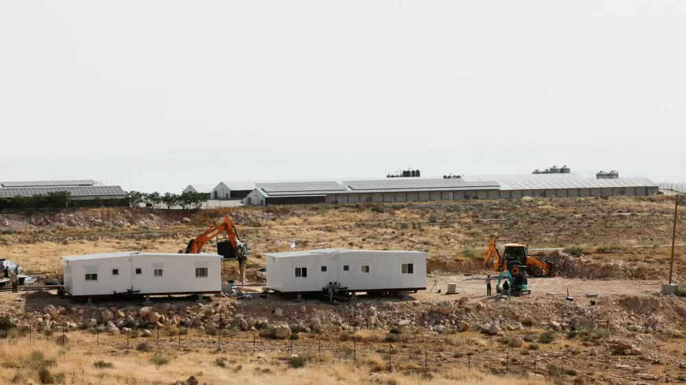 Israeli settlers install a new caravan near the Palestinian village of Um Al-Khair in Masafer Yatta in the Israeli-occupied West Bank, May 20, 2026. REUTERS/Mussa Qawasma