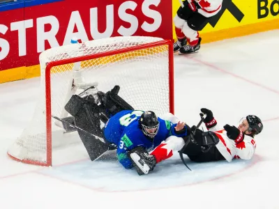 Canada's Emmitt Finnie, right, clashes against Slovenia's goaltender Zan Us during a preliminary round game between Canada and Slovenia at the men's ice hockey world championship in Fribourg, Switzerland, Friday May 22, 2026. (Salvatore Di Nolfi/Keystone via AP)