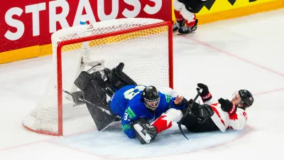 Canada's Emmitt Finnie, right, clashes against Slovenia's goaltender Zan Us during a preliminary round game between Canada and Slovenia at the men's ice hockey world championship in Fribourg, Switzerland, Friday May 22, 2026. (Salvatore Di Nolfi/Keystone via AP)