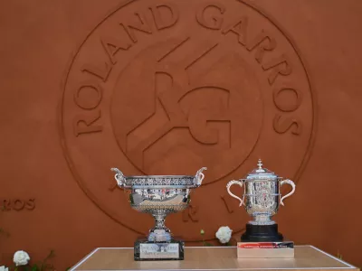 The men's, left, and women's trophies are displayed in-front of the Roland-Garros logo during qualifications for the French Open tennis tournament in Paris, Friday, May 22. (AP Photo/Emma Da Silva)