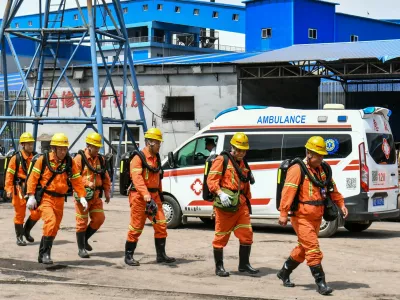 In this photo released by Xinhua News Agency, rescue workers pass by an ambulance in the aftermath of an explosion at Changzhi city's Liushenyu coal mine in Qinyuan county, northern China's Shanxi Province on Saturday, May 23, 2026. (Cao Yang/Xinhua via AP)