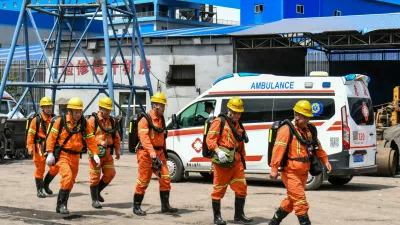 In this photo released by Xinhua News Agency, rescue workers pass by an ambulance in the aftermath of an explosion at Changzhi city's Liushenyu coal mine in Qinyuan county, northern China's Shanxi Province on Saturday, May 23, 2026. (Cao Yang/Xinhua via AP)