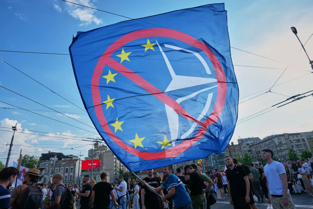 Anti-government protesters, waving an anti NATO and European Union flag take part in a rally led by Serbia's protesting university students who are pushing for major political changes in the Balkan country run by President Aleksandar Vucic, in Belgrade, Serbia, Saturday, May. 23, 2026. (AP Photo/Darko Vojinovic)