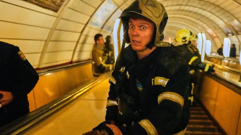 A firefighter reacts on missiles' strikes as he goes down the escalator to a metro shelter during Russia's missile and drone attacks on capital Kyiv, Ukraine, early Sunday, May 24, 2026. (AP Photo/Efrem Lukatsky)