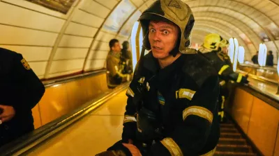 A firefighter reacts on missiles' strikes as he goes down the escalator to a metro shelter during Russia's missile and drone attacks on capital Kyiv, Ukraine, early Sunday, May 24, 2026. (AP Photo/Efrem Lukatsky)
