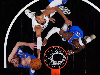 San Antonio Spurs forward Victor Wembanyama (1) drives to the basket against Oklahoma City Thunder center Chet Holmgren (7) and guard Shai Gilgeous-Alexander (2) during the first half in Game 4 in the Western Conference finals NBA basketball playoffs series in San Antonio, Sunday, May 24, 2026. (AP Photo/Eric Gay)