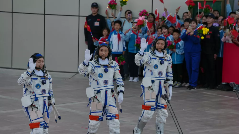 Astronaut for the Shenzhou 23 manned mission from left Hong Kong's Lai Ka-ying, identified by Chinese authorities as Li Jiaying using the Mandarin transliteration of the name, China's Zhu Yangzhu and Zhang Zhiyuan wave as they attend a see-off ceremony for their manned space mission at the Jiuquan Satellite Launch Center in northwestern China, Sunday, May 24, 2026. (AP Photo/Ng Han Guan)