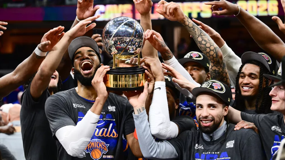 May 25, 2026; Cleveland, Ohio, USA; New York Knicks center Karl-Anthony Towns (32) and guard Jose Alvarado (5) help the team lift the trophy after defeating the Cleveland Cavaliers in game four of the eastern conference finals for the 2026 NBA playoffs at Rocket Arena. Mandatory Credit: Ken Blaze-Imagn Images