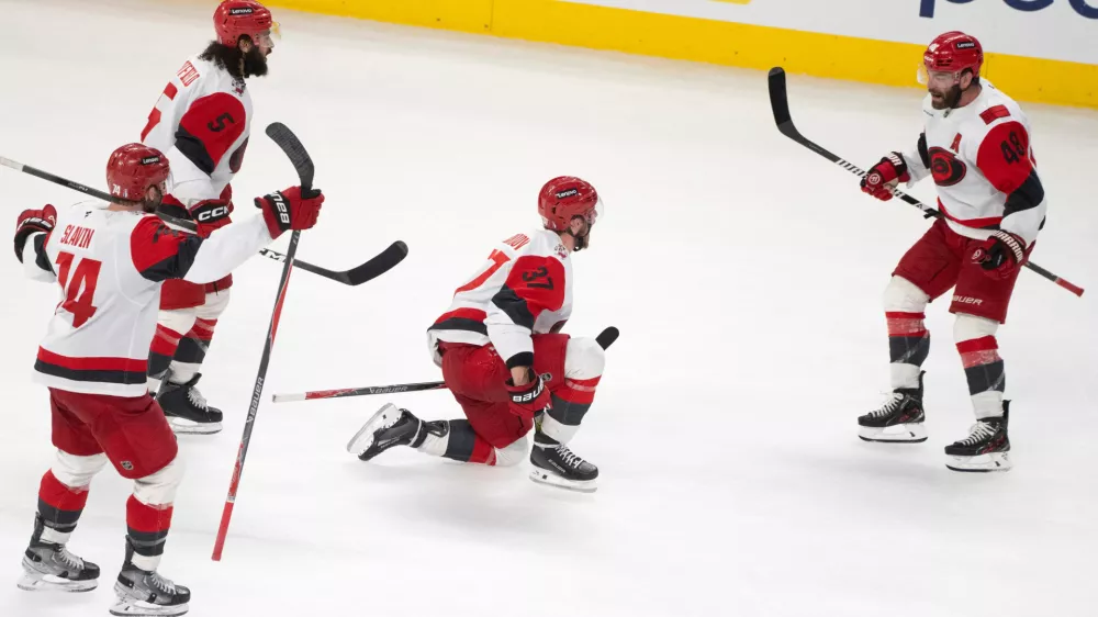 Carolina Hurricanes' Andrei Svechnikov (37) celebrates with teammates Jaccob Slavin (74), Jalen Chatfield (5) and Jordan Martinook (48) after his goal during overtime of Game 3 of the Eastern Conference finals NHL hockey Stanley Cup playoff series against the Montreal Canadiens in Montreal, Monday, May 25, 2026. (Christinne Muschi/The Canadian Press via AP) CORRECTION: Corrected the goal scorer to Andrei Svechnikov