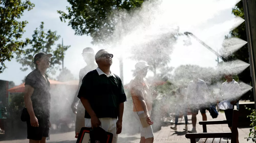 Tennis - French Open - Roland Garros, Paris, France - May 25, 2026 Spectators cool down by a water spray station during heatwave in Paris REUTERS/Benoit Tessier   TPX IMAGES OF THE DAY