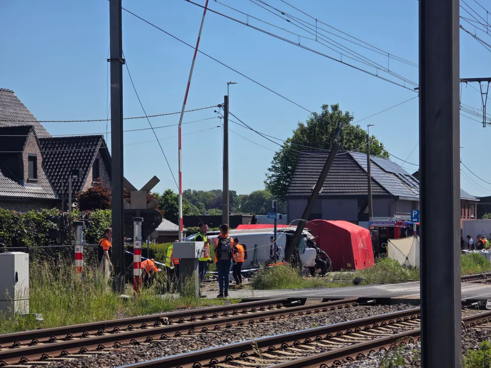 Rescue workers on the scene of a crash between a train and vehicle in Buggenhout, Belgium, Tuesday, May 26, 2026. (AP Photo/Koen Baten)