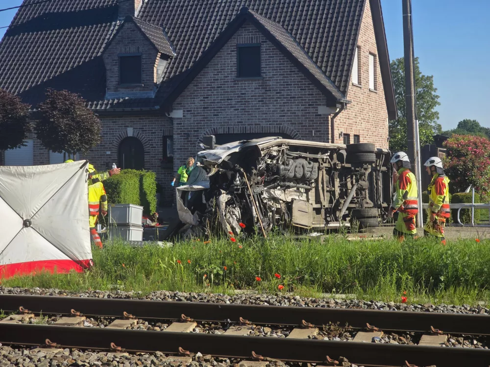 Rescue workers on the scene of a crash between a train and vehicle in Buggenhout, Belgium, Tuesday, May 26, 2026. (AP Photo/Koen Baten)