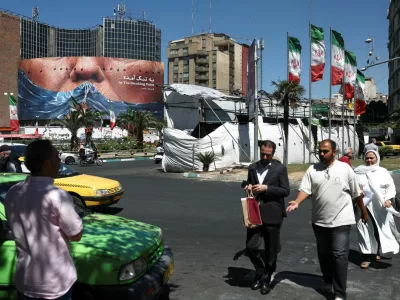 People walk past an anti-U.S. billboard depicting U.S. President Donald Trump and the Strait of Hormuz, in Tehran, Iran, May 26, 2026. Majid Asgaripour/WANA (West Asia News Agency) via REUTERS ATTENTION EDITORS - THIS PICTURE WAS PROVIDED BY A THIRD PARTY