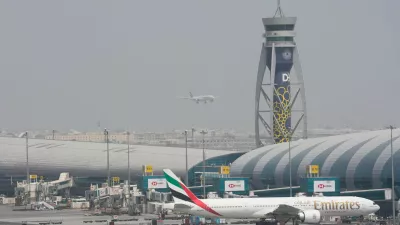 FILE - An Emirates Boeing 777 stands at the gate at Dubai International Airport as another prepares to land on the runway in Dubai, United Arab Emirates, Aug. 17, 2022. (AP Photo/Jon Gambrell, File)