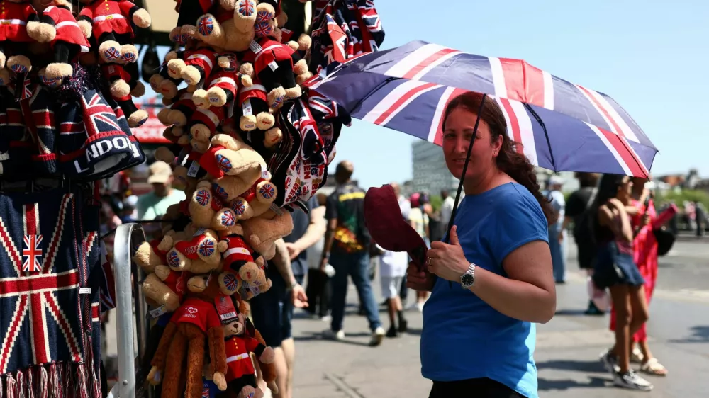 A gift stall worker shields herself from the sun with a Union Jack umbrella during a heatwave, after the UK recorded its hottest May bank holiday ever, in London, Britain, May 26, 2026. REUTERS/Jack Taylor / Foto: Jack Taylor