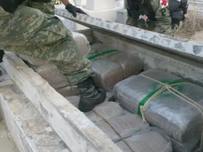 Soldiers remove a tombstone to display marijuana packages in this July 26, 2012 handout photograph released to Reuters on July 28. The Army located 241 packages of marijuana, weighing more than two tons, hidden in cemetery tombstones in the city of Camargo, in the Mexican state of Tamaulipas, according to the Defence Minister (SEDENA) statement. Picture taken July 26, 2012. REUTERS/Sedena/Handout (MEXICO - Tags: MILITARY DRUGS SOCIETY) FOR EDITORIAL USE ONLY. NOT FOR SALE FOR MARKETING OR ADVERTISING CAMPAIGNS. THIS IMAGE HAS BEEN SUPPLIED BY A THIRD PARTY. IT IS DISTRIBUTED, EXACTLY AS RECEIVED BY REUTERS, AS A SERVICE TO CLIENTS