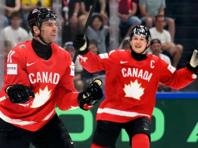 Canada's John Tavares, left, celebrates scoring with Macklin Celebrini, right, during the Group B preliminary round between the Czech Republic and Canada at the men's ice hockey world championship in Fribourg, Switzerland, Tuesday, May 26, 2026. (Laurent Gillieron/Keystone via AP)