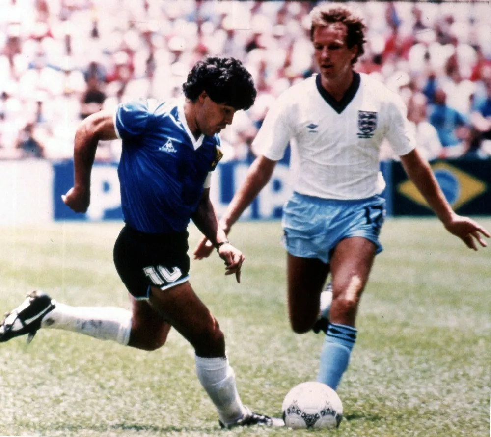 Argentine soccer player Diego Maradona, left, tries to go past England's Trevor Steven, during the World Cup quarter final match, in the Aztec Stadium, Mexico City, on June 22, 1986. (AP Photo) / Foto: Ap