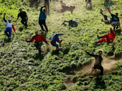 Participants compete in a race during the annual Cooper's Hill Cheese Rolling competition near Brockworth, Britain May 25, 2026. REUTERS/Isabel Infantes  TPX IMAGES OF THE DAY / Foto: Isabel Infantes