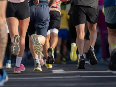 close up of diverse marathon runners feet in athletic shoes running on city pavement in Ljubljana urban marathon event on sunny day / Foto: Jairo Mesa
