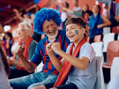 Happy boy and his grandfather cheering during sports game at the stadium. / Foto: Drazen Zigic