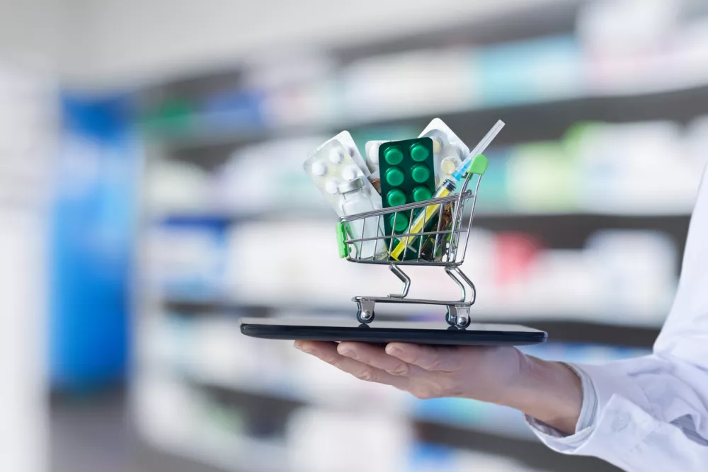 The concept of online medicine trading. The doctor shows a shopping cart with medicines on his tablet. / Foto: Natali_mis Getty Images
