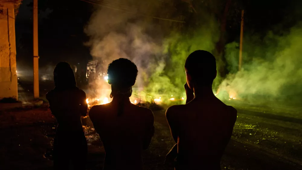 People look at a barricade set up by residents protesting against prolonged power outages in Havana, Cuba, Wednesday, May 13, 2026. (AP Photo/Ramon Espinosa)