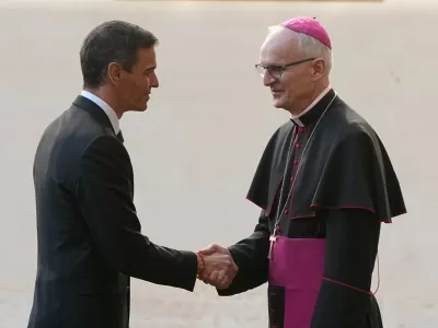Spain's Premier Pedro Sanchez is welcomed by Archbishop Petar Rajic, Prefect of the Prefecture of the Papal Household as he arrives at the St. Damasus courtyard ahead of their private audience with Pope Leo XIV at the Vatican, Wednesday, May 27, 2026. (AP Photo/Alessandra Tarantino)
