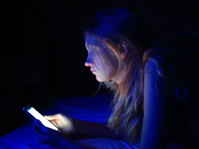 young woman using the smart phone on bed before sleep