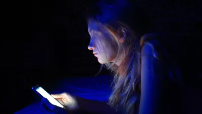 young woman using the smart phone on bed before sleep
