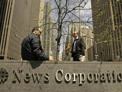 Two men eat lunch while seated outside News Corporation's corporate headquarters, Tuesday, May 1, 2007 in New York. Dow Jones & Co., publisher of the Wall Street Journal, said Tuesday it received an unsolicited bid from Rupert Murdoch's News Corporation to buy the company for  billion. The news sent shares of News Corp. soaring and those of other newspaper higher. (AP Photo/Kathy Willens)